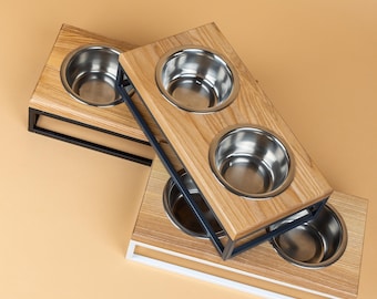 Comedero para mascotas de estilo industrial con plataforma de madera de fresno sobre elevación de acero, cuencos de acero inoxidable y almohadillas antideslizantes.