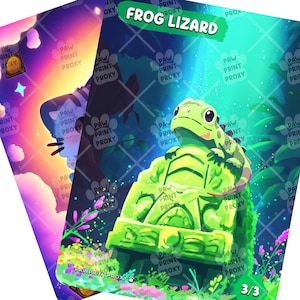 May include: Two illustrated cards. One card features a cat silhouette against a colorful sky. The other card has a green frog on a green stone structure with the text "FROG LIZARD" and the number "3/3".
