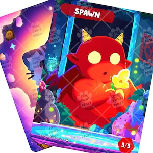Peut inclure: Deux cartes à collectionner sur le thème de la fantaisie. L'une représente une créature rouge diabolique tenant une fleur jaune, avec le mot "SPAWN" en haut. L'autre carte a un design cosmique coloré. Les deux cartes ont le texte "3/3" en bas.