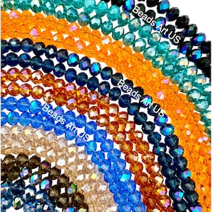 May include: Assortment of faceted glass beads in various colors, including teal, orange, amber, brown, blue, and black. The beads are arranged in rows, with the text "Beads Art US" visible on the top row.