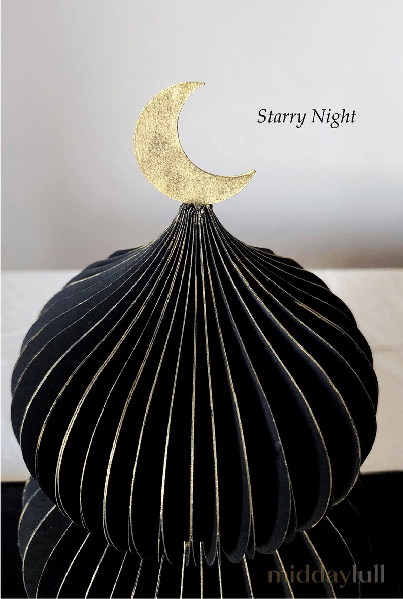 May include: A closeup of black decorative mosque dome with gold accents and a gold crescent moon on top. The text "Starry Night" is visible on the right side of the image. The product is from middaylull.