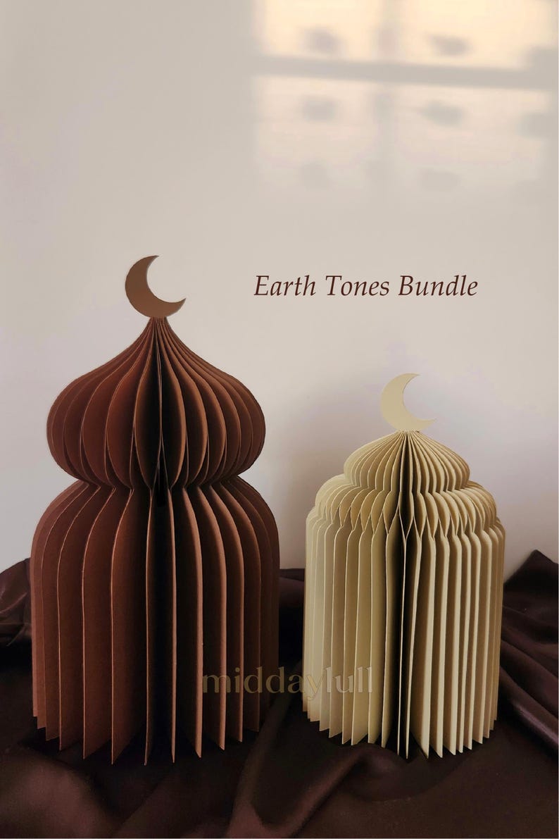 May include: Two paper sculptures in earth tones, resembling domed structures, are displayed. One is a deep brown, the other a light beige. Each has a crescent moon on top. The text "Earth Tones Bundle" is visible.