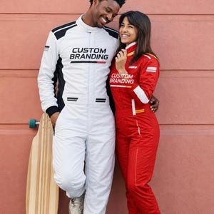 May include: A white racing jumpsuit with black accents and the text CUSTOM BRANDING on the chest, alongside a red racing jumpsuit with white accents and the text CUSTOM BRANDING on the chest, positioned next to a longboard with a wooden deck.