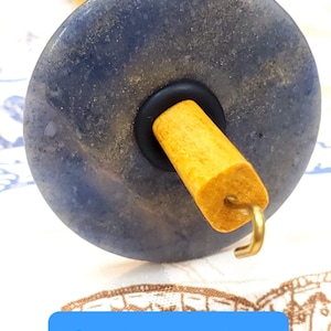 May include: A blue aventurine spinning wheel with a wooden spindle and a metal hook.