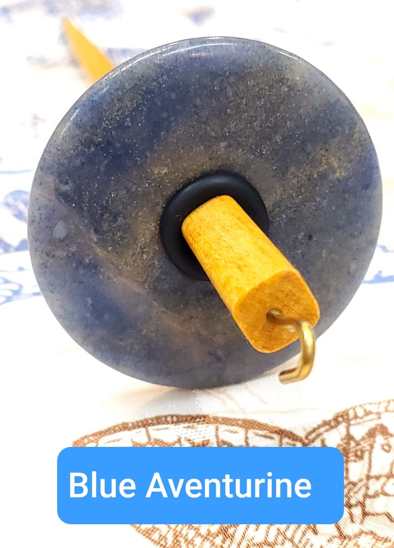 May include: A blue aventurine spinning wheel with a wooden spindle and a metal hook.