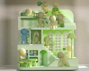 May include: A light green miniature house sculpture with multiple levels, featuring small, stylized figures in various poses. Some figures are light yellow, others blue. The house has windows, stairs, and a lamp.