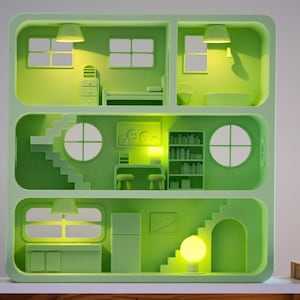 Puede incluir: Una casa de mu&ntilde;ecas verde con varias habitaciones, incluyendo un dormitorio, un ba&ntilde;o y una cocina. La casa tiene escaleras, ventanas y muebles. El interior est&aacute; iluminado con luces amarillas, creando un brillo c&aacute;lido. El dise&ntilde;o es minimalista y moderno.