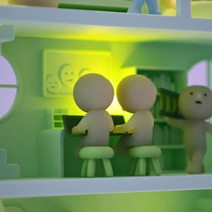 Puede incluir: Una escena de casa en miniatura caprichosa, de color verde claro, con varias figuras peque&ntilde;as de cabeza redonda. Dos figuras est&aacute;n sentadas en un escritorio con un port&aacute;til, mientras que otra lleva una peque&ntilde;a escalera. La escena incluye una escalera, una ventana y una pared con una imagen.