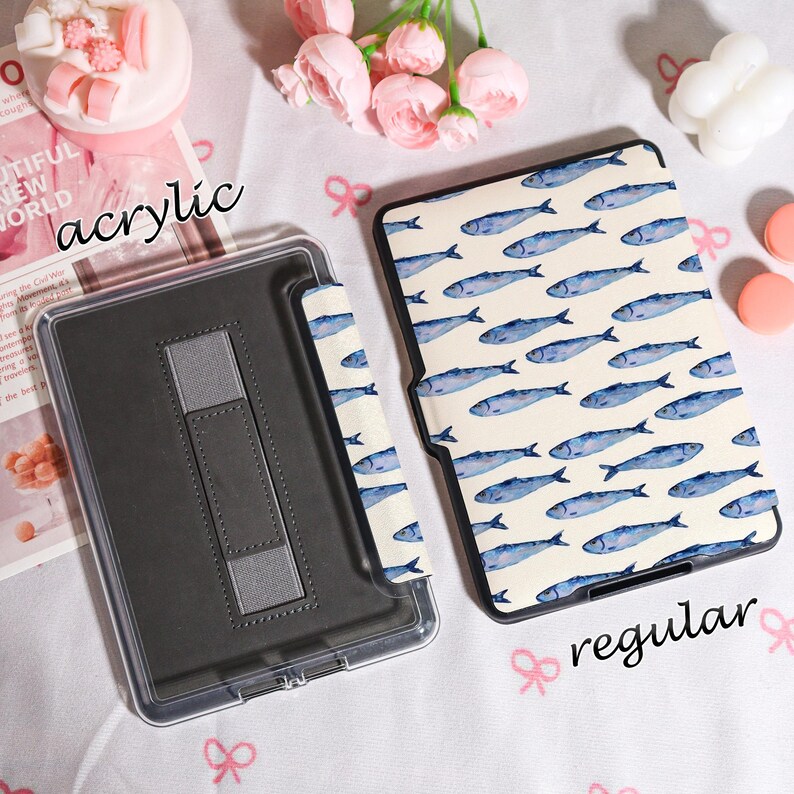 May include: Two tablet cases are displayed. One is clear acrylic, and the other has a cream background with blue fish illustrations. The acrylic case has a gray stand. The text "acrylic" and "regular" are visible.