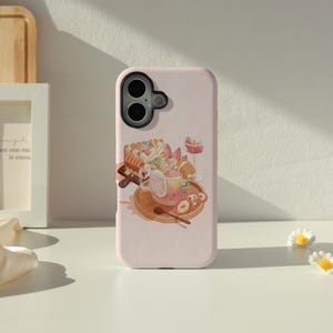May include: A light pink phone case with a dessert-themed illustration. The design features a cup of tea, a slice of cake, and fruit slices. The case has a glossy finish and a camera cutout.