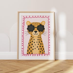 Cute cheetah art print with flower-shaped sunglasses for kids nursery decor - adorable leopard poster with pink scalloped border perfect for children's bedroom wall art, baby room decoration, playroom prints, safari animal theme nursery, wild cat illustration, toddler room decor, modern kids art, colorful animal print, whimsical wildlife poster, nursery wall decor, children's art print, baby shower gift, kid's room accessories, animal lover gift, jungle theme decor.