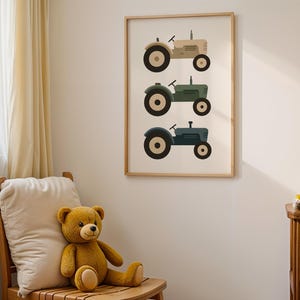 Vintage tractor wall art hanging above cozy reading nook with armchair and teddy bears, farm themed toddler boy nursery decor, three tractors in neutral beige green blue palette, rustic farmhouse kids bedroom wall hanging, soft cream nursery with warm sunlight aesthetic, minimalist vehicle poster in natural wood frame, charming reading corner decoration for little ones, country style transportation artwork for boys room, calm serene children's space design, scandi farm nursery inspiration.