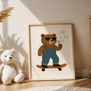 Cool skateboarding bear wall art printable in boho nursery with pampas grass and warm natural light – cute bear with sunglasses, denim overalls, and bubbles on skateboard – digital download poster for baby room or toddler nursery – modern bohemian kids room decor with neutral tones – bear illustration for gender-neutral nursery – instant download animal wall art – wooden frame children’s poster – cozy boho nursery inspiration with teddy bear and crib.