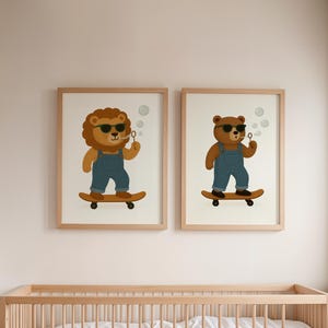 Set of two nursery wall art prints featuring skateboarding lion and bear with sunglasses and overalls – digital download animal posters above wooden crib – printable kids room decor in modern neutral style – twin animal illustrations with bubbles on skateboards – instant download gallery wall art for baby nursery or toddler bedroom – matching woodland animal poster set – lion and bear nursery prints for gender-neutral children's room styling.