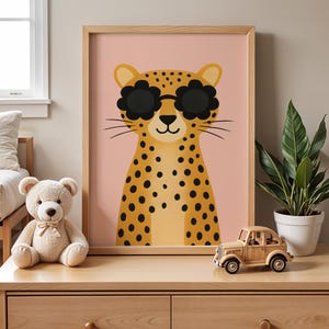 Modern nursery shelf styling with leopard wall art - cute spotted cheetah print with sunglasses on wooden dresser, boho kids room decor with snake plant and wooden toy car, contemporary animal poster for toddler bedroom, pink background safari nursery art, natural wood frame children's wall decor, modern nursery furniture styling ideas, plant parent nursery decor, trendy kids room accessories, wooden toys and animal prints nursery theme, stylish baby room wall hanging, jungle themed nursery.