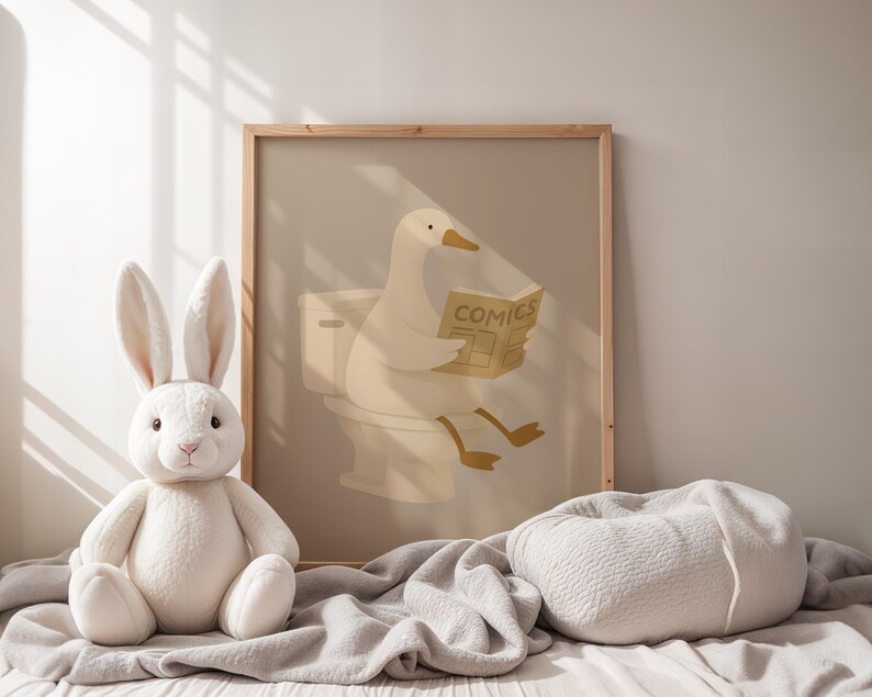 Neutral nursery wall art print, soft beige duck bathroom poster, minimalist children's room decor, gentle animal illustration art, calm nursery bathroom sign, Scandinavian baby room print, warm neutral kids wall art, peaceful nursery poster, duck reading newspaper illustration, natural wood frame nursery art, monochromatic baby room decor, hygge children's wall hanging, serene kids bathroom art, gender neutral nursery print, modern minimalist baby decor, soft color palette children's art.
