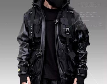 May include: A black leather jacket with a black hooded sweatshirt underneath. The jacket has multiple pockets and straps, and the sweatshirt has a zipper closure. The model is wearing a black face mask and black pants with yellow straps.