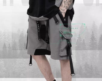 Op de afbeelding: Grijze cargo shorts met meerdere zakken en zwarte banden. De shorts hebben een zwart-grijs kleurenblokontwerp.