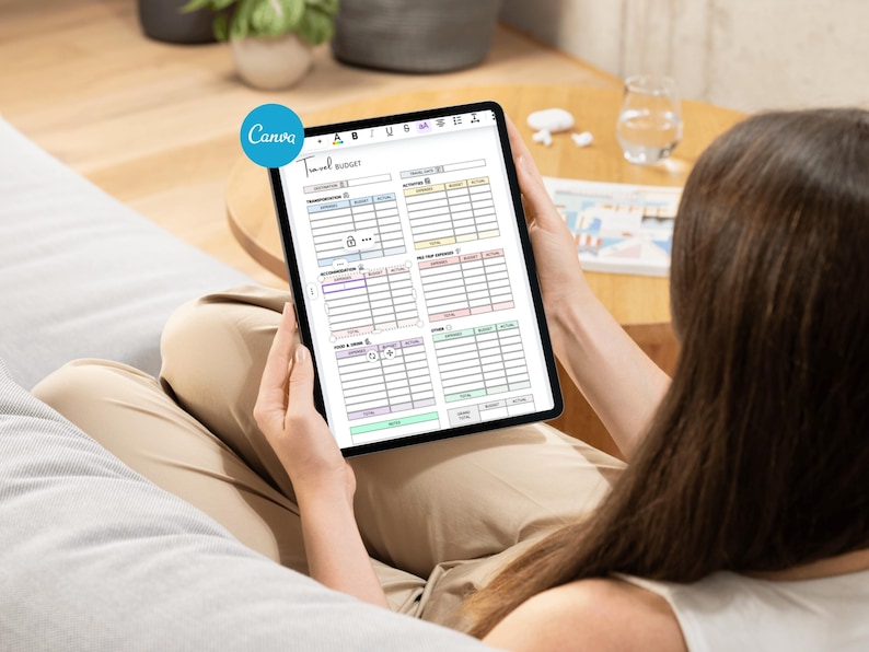 May include: A digital tablet displaying a "Travel Budget" template with various expense categories. The template includes sections for transportation, accommodation, and food. The Canva logo is visible in the upper left corner.
