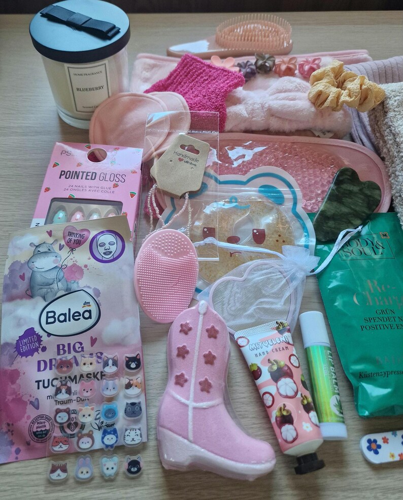 K&ouml;nnte beinhalten: Eine Auswahl an Beauty- und Pflegeprodukten, darunter eine Kerze, Gesichtsmasken, ein Nagelset, ein rosa Cowboy-Stiefel und verschiedene Hautpflegeartikel. Die Artikel sind auf einer hellen Oberfl&auml;che angeordnet.