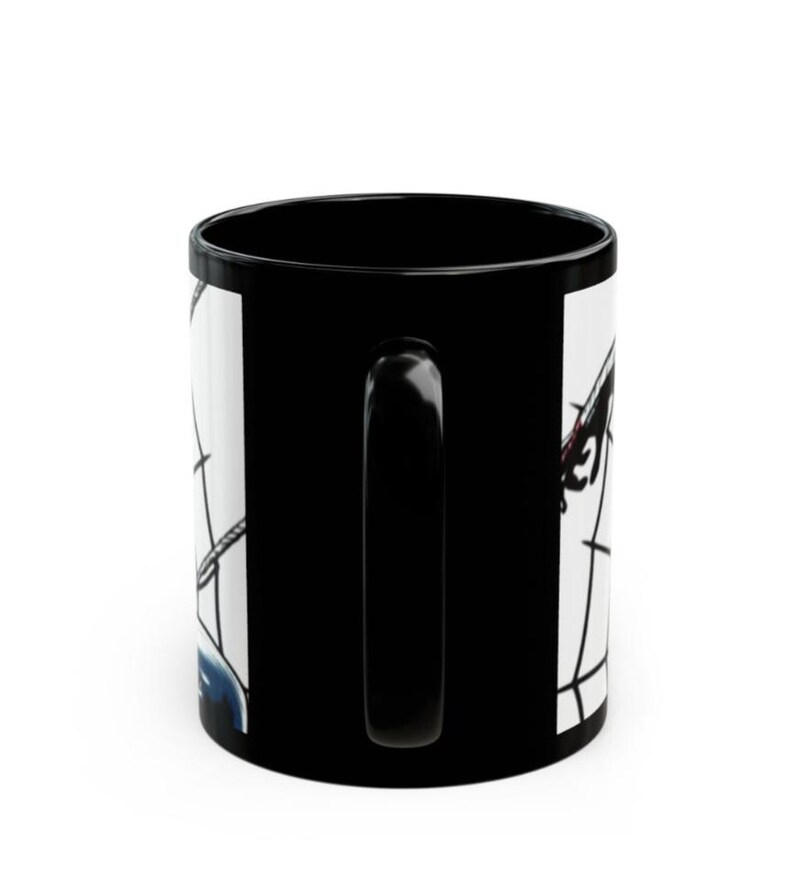 May include: Black coffee mug with a white graphic design. The mug features a black handle and a glossy finish. The graphic design appears to be a stylized illustration with black and red elements.