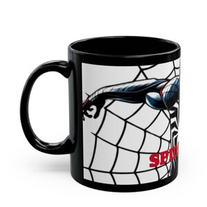 May include: Black ceramic mug featuring a graphic of Spider-Man in a web. The design includes a black and blue Spider-Man figure with the word "SPIDER" in red. The mug has a black handle and interior.