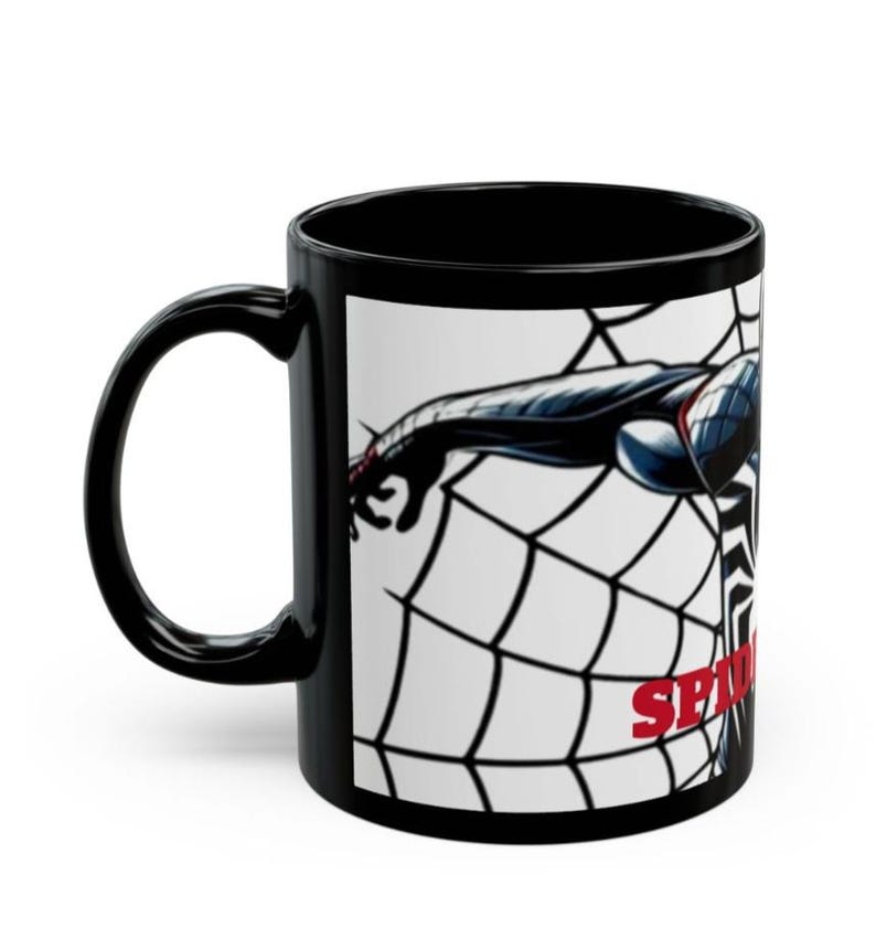 May include: Black ceramic mug featuring a graphic of Spider-Man in a web. The design includes a black and blue Spider-Man figure with the word "SPIDER" in red. The mug has a black handle and interior.