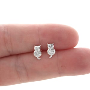 Op de afbeelding: Een paar zilveren oorbel studs in de vorm van een kat met heldere zirkonia stenen.