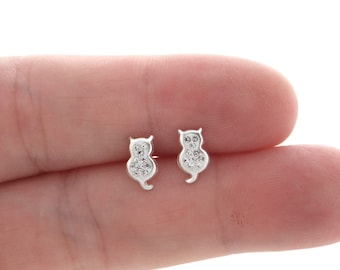Peut inclure: Une paire de boucles d'oreilles clous en argent en forme de chat avec des pierres en oxyde de zirconium transparentes.