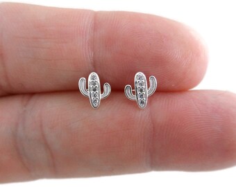 May include: A pair of silver cactus stud earrings with clear cubic zirconia stones.