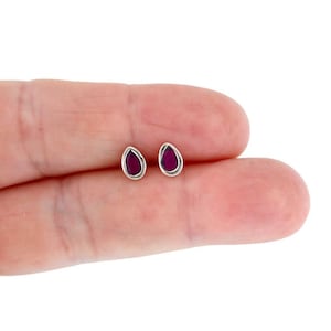 Może przedstawiać: Para srebrnych kolczyków z fioletowymi kamieniami szlachetnymi w kształcie łzy.