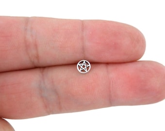 May include: A small silver charm with a pentagram design.
