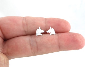 May include: A pair of silver unicorn head stud earrings. The earrings are small and delicate, and they are perfect for adding a touch of whimsy to any outfit.