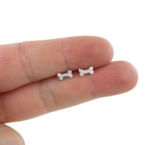 May include: A pair of silver bone-shaped stud earrings. The earrings are small and delicate, and they are perfect for everyday wear.