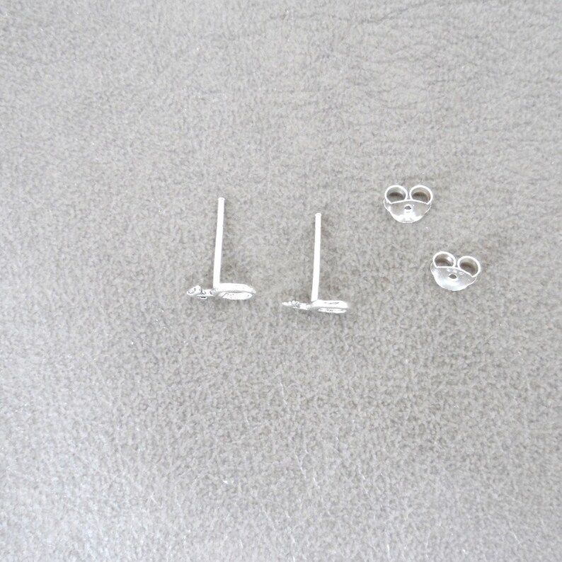 May include: A pair of silver butterfly stud earrings with a push-back closure.