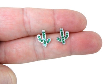 May include: A pair of silver cactus stud earrings with green crystal accents.
