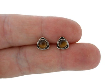 Puede incluir: Un par de pendientes de plata triangulares con piedras de ojo de tigre marrón.