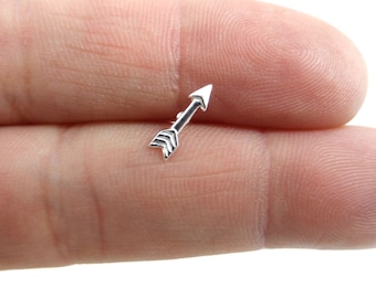 May include: A silver arrowhead earring with a simple design.