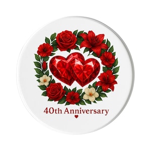 Può includere: Un oggetto decorativo rotondo bianco con due cuori rossi a forma di gemma circondati da una ghirlanda di rose rosse, gigli e piccoli fiori bianchi. Il testo "40th Anniversary" è in rosso.
