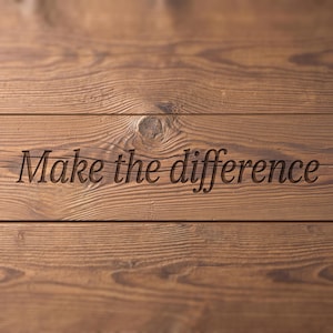 Könnte beinhalten: Eine braune Holzoberfläche mit horizontalen Dielen, einer sichtbaren Maserung und einem Astloch. Der Text "Make the difference" ist mittig in einer dunklen Serifenschrift in das Holz eingraviert, was eine vertiefte Optik auf der Oberfläche erzeugt.