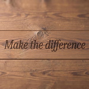 May include: A brown wooden surface featuring horizontal planks with a visible grain pattern and a knot. The text "Make the difference" is engraved into the center of the wood in a dark, serif font, creating a recessed appearance on the surface.