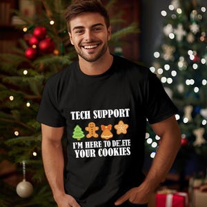 Könnte beinhalten: Schwarzes T-Shirt mit dem Text "TECH SUPPORT" über Lebkuchen-Design. Darunter steht der Satz "I'M HERE TO DELETE YOUR COOKIES". Das T-Shirt wird von einer Person getragen.