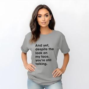 Funny Sarcastic Shirt, “And Yet, Despite The Look On My Face, You’re Still Talking”, Witty Graphic Tee, Unisex Humor Shirt, Gift for Friends