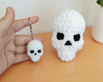Puede incluir: Dos decoraciones de calaveras de ganchillo blancas. Una es un llavero y la otra es una pieza independiente más grande. Ambas tienen ojos y nariz negros. Las calaveras están hechas de un hilo suave y texturizado.