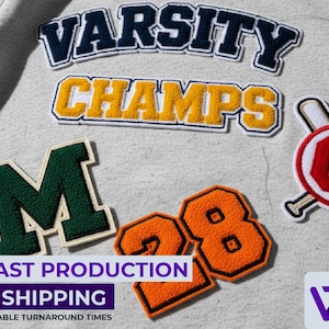 以下が含まれることがあります： 紺色と金色で「VARSITY」と「CHAMPS」の文字、緑色の「M」、オレンジ色の「28」など、さまざまな刺繍パッチのクローズアップ。野球をテーマにしたパッチも表示されています。パッチはグレーの生地にあります。