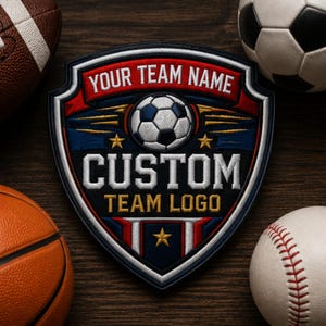 Puede incluir: Un parche bordado en forma de escudo con un gráfico de balón de fútbol, pancartas rojas con el texto YOUR TEAM NAME y las palabras CUSTOM TEAM LOGO en blanco y dorado. El diseño incluye tres estrellas doradas sobre un fondo azul y rojo.