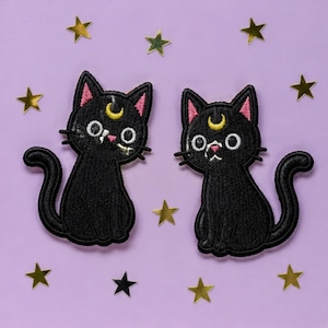 Peut inclure: Deux écussons brodés représentant des chats noirs avec des oreilles intérieures roses, des yeux blancs et un symbole de croissant de lune jaune sur le front. Les chats sont assis avec la queue recourbée, entourés de petites étoiles dorées.