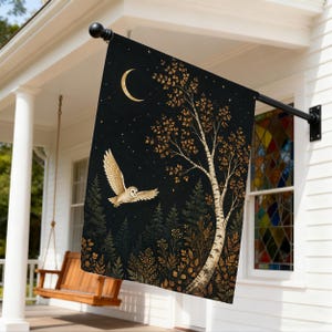Könnte beinhalten: Eine rechteckige Gartenflagge mit einem schwarzen Nachthimmel, einer goldenen Mondsichel und Sternen. Eine weiße Eule fliegt über eine dunkle Waldlandschaft mit einer markanten Birke und goldfarbenem Laub im Vordergrund.
