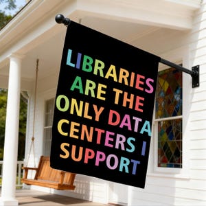 May include: A rectangular black garden flag featuring the multicolored text LIBRARIES ARE THE ONLY DATA CENTERS I SUPPORT. The letters are arranged in five lines with a gradient of blue, green, yellow, orange, and pink hues against the black background.
