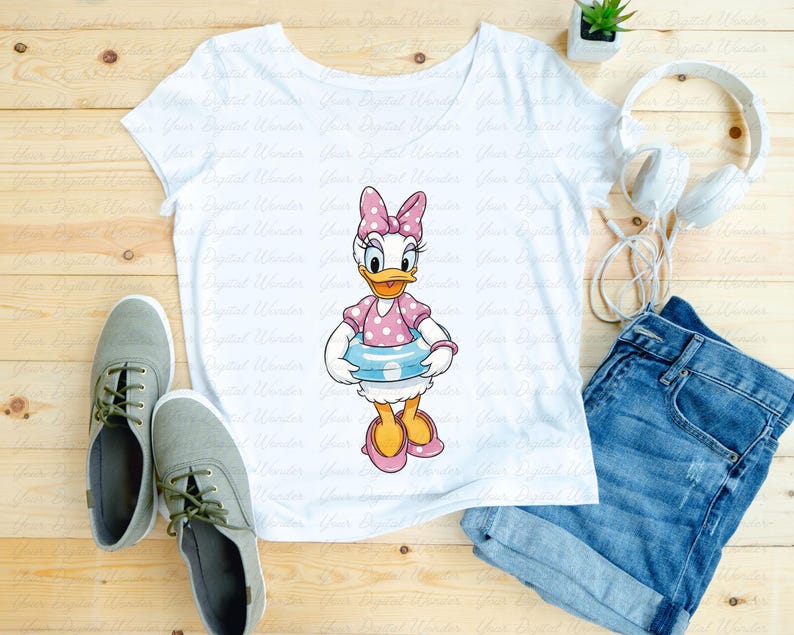 May include: White t-shirt featuring a cartoon image of Daisy Duck wearing a pink polka dot bow, dress, and shoes, and holding a blue and white inner tube. The shirt is paired with denim shorts and gray sneakers.